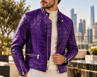 Puede incluir: Una chaqueta de cuero morado vibrante con un patrón texturizado de piel de cocodrilo, con cuello alto, cremalleras metálicas plateadas en la parte delantera y los puños, sobre un suéter de cuello alto color crema y pantalones claros.