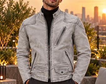 May include: A light gray leather jacket with a stand-up collar, a full-length front zipper, and multiple zippered pockets. The jacket features a small flap pocket on the lower front and is worn over a black turtleneck sweater. The ORIXO LEATHER logo is visible.