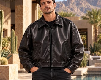 May include: A black leather jacket with a classic collar, a full-length front zipper, and elasticized hem detailing. The jacket features long sleeves with cuffs and two side pockets. The ORIXO LEATHER logo is visible in the top left corner.
