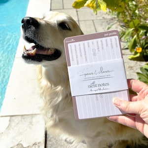 May include: A set of ten pet profile planner cards with a mauve and white colour scheme. The cards feature printed fields for pet information including name, birthday, and vet contact details. The band is labelled with the text paws & claws and nest notes.
