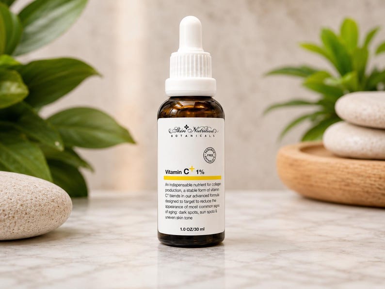 K&ouml;nnte beinhalten: Eine braune Glastropfflasche mit Skin Nutrition Botanicals Vitamin C+ 1% Serum. Das wei&szlig;e Etikett zeigt schwarzen Text, eine gelbe Akzentlinie und ein kreisf&ouml;rmiges Paraben Free Siegel. Die Flasche enth&auml;lt 30 ml Fl&uuml;ssigkeit und hat einen wei&szlig;en Tropfverschluss.