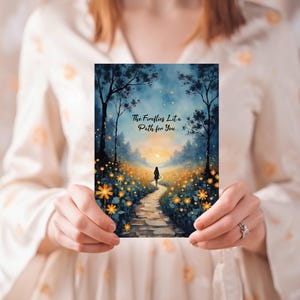 May include: A rectangular art print featuring a watercolor painting of a path through a field of yellow flowers, leading to a figure in the distance. The text "The Fireflies Lit a Path for You" is at the top.