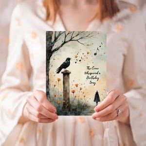 May include: A watercolor birthday card featuring a black crow perched on a pillar, with musical notes and the text "The Crow Whispered a Birthday Song." The card has a whimsical, artistic design with a tree and flowers.