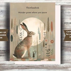 May include: A folk-art style greeting card from the Quiet Company of Wandering Hares Collection. The card features a seated hare illustration with the text "Thistlewhisk" and "Wonder grows where you pause." Includes 6 note cards and 6 white envelopes. Card dimensions are 4.5" x 5.5".