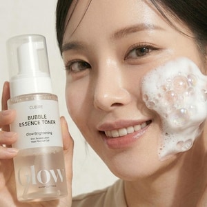 Puede incluir: Un frasco con bomba de plástico transparente de CURE: BUBBLE ESSENCE TONER Glow Brightening con Serine Lotion y May Peony Gel. El frasco tiene una etiqueta blanca con texto negro y la palabra Glow impresa en letras blancas grandes.