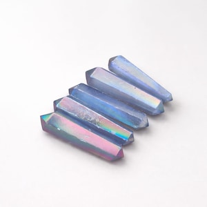 May include: Five double-terminated crystal points arranged in a parallel row. Each crystal features a smooth, elongated hexagonal shape with a metallic, iridescent finish that shifts between shades of light blue, violet, and soft pink hues.