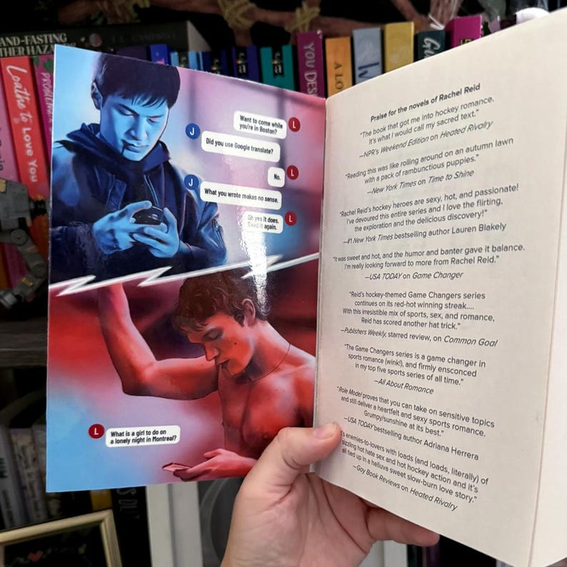 May include: A book with an open cover featuring a split-screen illustration of two people using phones. The top panel shows a person in blue tones, and the bottom shows a person in red tones. The right page contains printed praise for Rachel Reid.