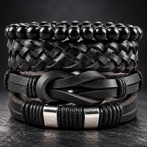 May include: A set of four stacked black bracelets. The top is a beaded strand, followed by a braided leather band, a leather strap with a central knot detail, and a bottom leather band featuring two silver-toned metal accents.