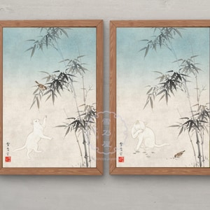 以下が含まれることがあります： 竹林の中で白い猫と鳥が描かれた、墨絵風の壁掛けアート2枚セット。左側の絵には鳥に手を伸ばす猫が、右側の絵には鳥のそばで毛づくろいをする猫が描かれています。どちらも木製のフレームに入っています。