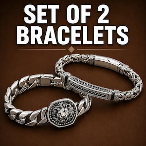 May include: A set of 2 bracelets featuring silver-toned metal. One bracelet has a thick curb chain with a central octagonal lion head emblem. The second bracelet features a woven Byzantine chain with a rectangular engraved bar and a clasp.