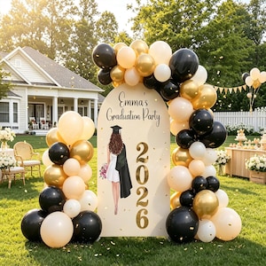 Peut inclure: Un panneau arqué pour Emma's Graduation Party 2026 avec une illustration d'une personne diplômée en robe blanche et toque, entouré d'une arche de ballons noirs, dorés et crème avec des confettis dorés éparpillés sur une pelouse verte.