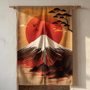 Könnte beinhalten: Ein Noren-Stoffvorhang mit geteiltem Design, bedruckt mit einer Landschaft aus einem schneebedeckten Berg, einer großen roten Sonne, fliegenden schwarzen Vögeln und einer stilisierten Baum-Silhouette auf beigem und orangefarbenem Grund.