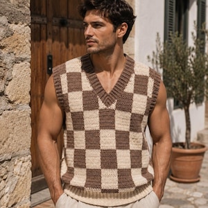 May include: A sleeveless V-neck sweater vest featuring a brown and cream checkered pattern. The garment is constructed with a ribbed neckline, armholes, and hem, showcasing a consistent block-style knit design throughout the front of the piece.