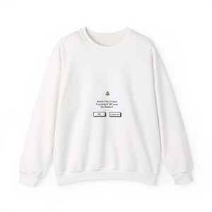 Op de afbeelding: Een wit sweatshirt met lange mouwen en een grafische print van een computermelding. De tekst luidt "Have You Tried Turning It Off and On Again?" met "OK"- en "Cancel"-knoppen en een geel waarschuwingsdriehoek-icoon erboven.