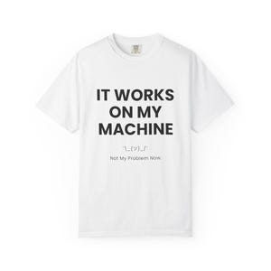 Peut inclure: Un t-shirt blanc à manches courtes avec le texte noir IT WORKS ON MY MACHINE, un émoticône haussement d'épaules et le texte Not My Problem Now. Le t-shirt présente un col rond et une coupe standard, offrant un design épuré sur un tissu blanc.