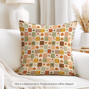 May include: A square throw pillow featuring a patchwork grid pattern with alternating squares of orange, green, and brown. The design includes illustrations of pumpkins, mushrooms, autumn leaves, small bows, and various checkered patterns.