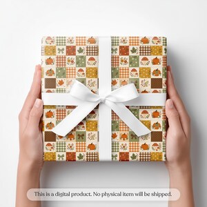 May include: A square gift box wrapped in paper with a patchwork pattern of autumn motifs including orange pumpkins, red mushrooms, green leaves, and brown gingham squares, tied with a white ribbon. Text reads: This is a digital product.