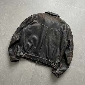 May include: A dark brown leather jacket featuring a distressed finish, a classic collar, long sleeves, and a back yoke. The hem includes adjustable side straps with metal buckles, providing a structured fit for this durable outer garment.
