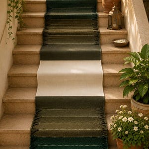 May include: A long, rectangular stair runner rug featuring a color-blocked design with deep forest green sections at the ends and a solid cream-colored center. The green sections include horizontal textured stripes and decorative fringe.