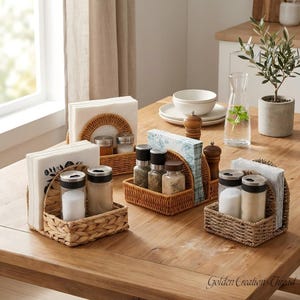 May include: Three woven rattan napkin holders with integrated spice storage compartments. Each holder features a semi-circular back panel and a rectangular base, containing glass spice jars with black lids and stacks of white paper napkins.