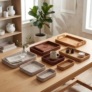 May include: A collection of rectangular and square woven rattan trays in various shades of light beige, medium brown, and dark brown. The trays feature raised edges and some include integrated handles. The text Golden Creation Thread is visible.