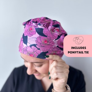 May include: A pink and green floral print surgical scrub hat with a matching ponytail tie.  Includes ponytail tie.
