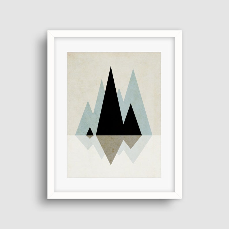 May include: A framed print of a geometric mountain landscape with black and blue triangles on a beige background. The mountains are reflected in the water below.