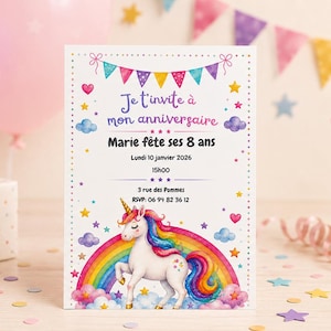 May include: A rectangular birthday invitation card featuring a white background with a colorful unicorn standing on a rainbow, surrounded by clouds, stars, and hearts. The text reads: Je t'invite &agrave; mon anniversaire, Marie f&ecirc;te ses 8 ans, Lundi 10 janvier 2026, 15H00, 3 rue des Pommes, RSVP: 06 94 82 36 12.