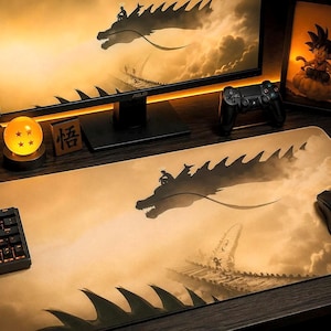 Peut inclure: Un tapis de bureau rectangulaire présentant une illustration sépia d'un grand dragon volant au-dessus d'une structure de toit traditionnelle. Le motif inclut la silhouette d'un personnage chevauchant le dragon avec des écailles sombres.