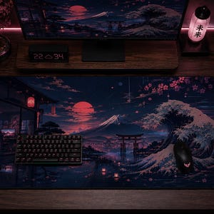 May include: A rectangular desk mat featuring a dark, atmospheric illustration of a Japanese landscape at night. The design includes a large red moon, a snow-capped mountain, a torii gate, a crashing wave, and cherry blossoms in shades of pink and blue.