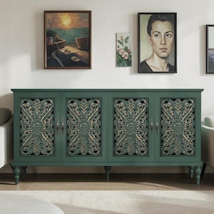 May include: A rectangular dark green sideboard featuring four cabinet doors with intricate, carved floral patterns in a lighter wood tone. The furniture piece stands on four turned legs and includes small, vertical metal handles on each door.