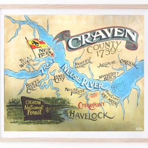 May include: A vintage-style map of Craven County, North Carolina, with the text "Craven County 1739" in a banner at the top. The map shows the Neuse River and surrounding areas, including New Bern, Havelock, Cherry Point, and the Croatan National Forest. The map is drawn in a whimsical style with blue water, green land, and brown roads.