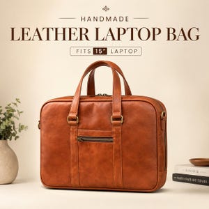May include: A tan leather laptop bag with two top handles, a front zippered pocket, and brass-toned hardware. The text above reads HANDMADE LEATHER LAPTOP BAG and FITS 15" LAPTOP. The bag features a rectangular shape with rounded corners.