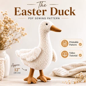 Pode incluir: Um brinquedo de pato de pelúcia feito de tecido sherpa branco com bico e pés marrons. O texto diz The Easter Duck PDF Sewing Pattern, Printable Pattern, Video Tutorial e Approx. 30 cm. O pato está sobre uma superfície clara.
