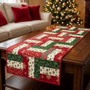 May include: A rectangular fabric table runner featuring a patchwork design with alternating strips of red, dark green, and white fabric. The pattern includes printed motifs of holly leaves, berries, and gold snowflakes on a cotton-like textile.