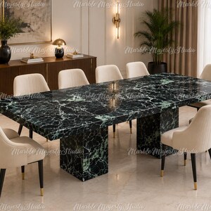 Pode incluir: Uma mesa de jantar retangular com um tampo de mármore polido em verde escuro e preto com veios brancos proeminentes, apoiada por duas bases de pedestal de mármore espessas a condizer, rodeada por oito cadeiras estofadas creme.