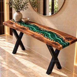 Op de afbeelding: Een rechthoekige sidetable met een blad van natuurlijk hout, voorzien van een centrale inleg van groene hars met ingebedde veelkleurige rivierstenen, rustend op een zwart metalen onderstel in de vorm van een X.