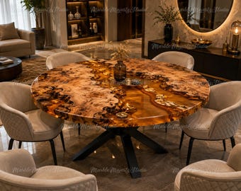 May include: A round dining table featuring a natural wood burl slab with a translucent amber resin river inlay, supported by a black metal base. The table is surrounded by five beige upholstered chairs with quilted back detailing.
