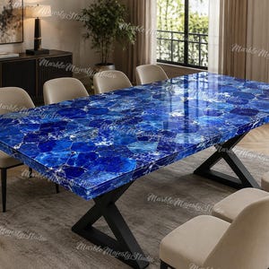 Può includere: Un tavolo da pranzo rettangolare con un piano in pietra preziosa blu lucidata caratterizzato da un mosaico di motivi cristallini blu intenso e bianchi, sostenuto da una base in metallo nero a forma di X e sei sedie beige.