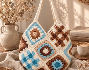 May include: A crochet tote bag constructed from various square motifs in shades of cream, light blue, and brown. The bag features a mix of floral-inspired patterns and geometric grid designs with two integrated handles at the top.