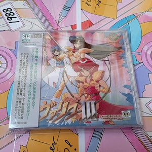 May include: A sealed CD-ROM jewel case featuring anime-style character illustrations in armour with the text Valis III. The cover art displays three figures in a dynamic pose with a metallic title logo. A vertical Japanese text strip is on the left side.