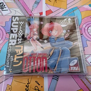 May include: A Super CD-ROM system video game case for Fantastic Night Dreams Cotton. The cover features anime-style characters, including a figure in a blue robe and another in a bikini, with the text Cotton and Super CD-ROM System printed clearly.