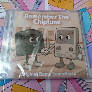 Może przedstawiać: Przezroczyste plastikowe etui na płytę CD z tytułem albumu Remember The Chiptune oraz Original Game Soundtrack. Okładka przedstawia czarną 16-bitową konsolę do gier i szarą konsolę przenośną, które podają sobie ręce na ringu bokserskim.