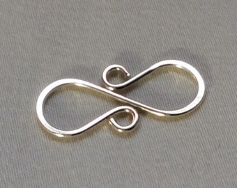 May include: Silver-toned metal clasp with a figure eight design. The clasp is made of a single piece of wire that is bent into two loops.