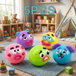 May include: A set of five colorful, round, plastic character balls with expressive faces. The collection includes a pink ball, a purple ball, a yellow ball with glasses, a green ball, and a blue ball with ears. The text 5PCS is visible above.
