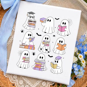 May include: A white canvas print featuring a pattern of nine cartoon ghosts reading colorful books. The ghosts are illustrated in black outlines with pastel-colored books, small spiders, spiderwebs, and bats scattered across the white background.