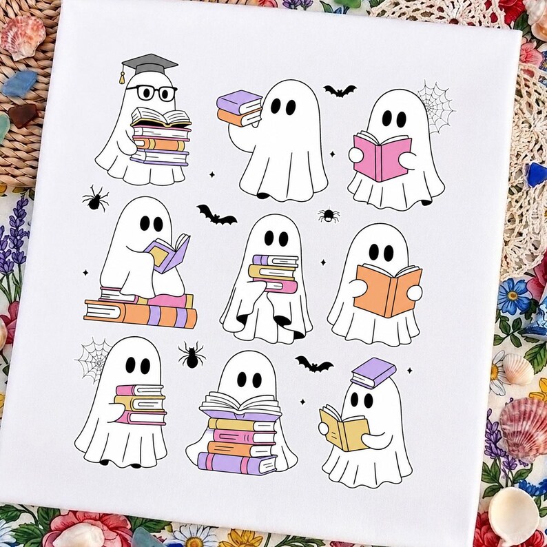 May include: A white fabric surface featuring a graphic print of nine cartoon ghosts in various poses, each interacting with colorful books. The ghosts are depicted with black eyes, some wearing glasses or graduation caps, surrounded by small spiders, bats, and webs.