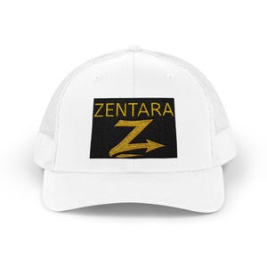 Peut inclure: Une casquette de type trucker blanche avec un écusson rectangulaire noir sur le devant. L'écusson affiche le mot ZENTARA en lettres dorées au-dessus d'une lettre Z dorée stylisée avec une queue en forme de flèche pointant vers la droite.