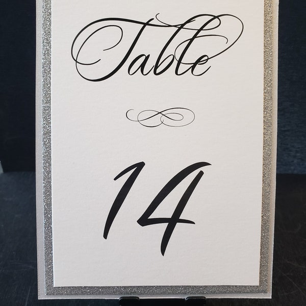 Tarjetas de números para mesas de boda con purpurina plateada