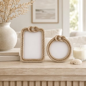 May include: Two picture frames with a tan rope border and a decorative knot at the top. One frame is rectangular and the other is circular. Both frames feature a white center area for displaying photographs or artwork on a flat surface.